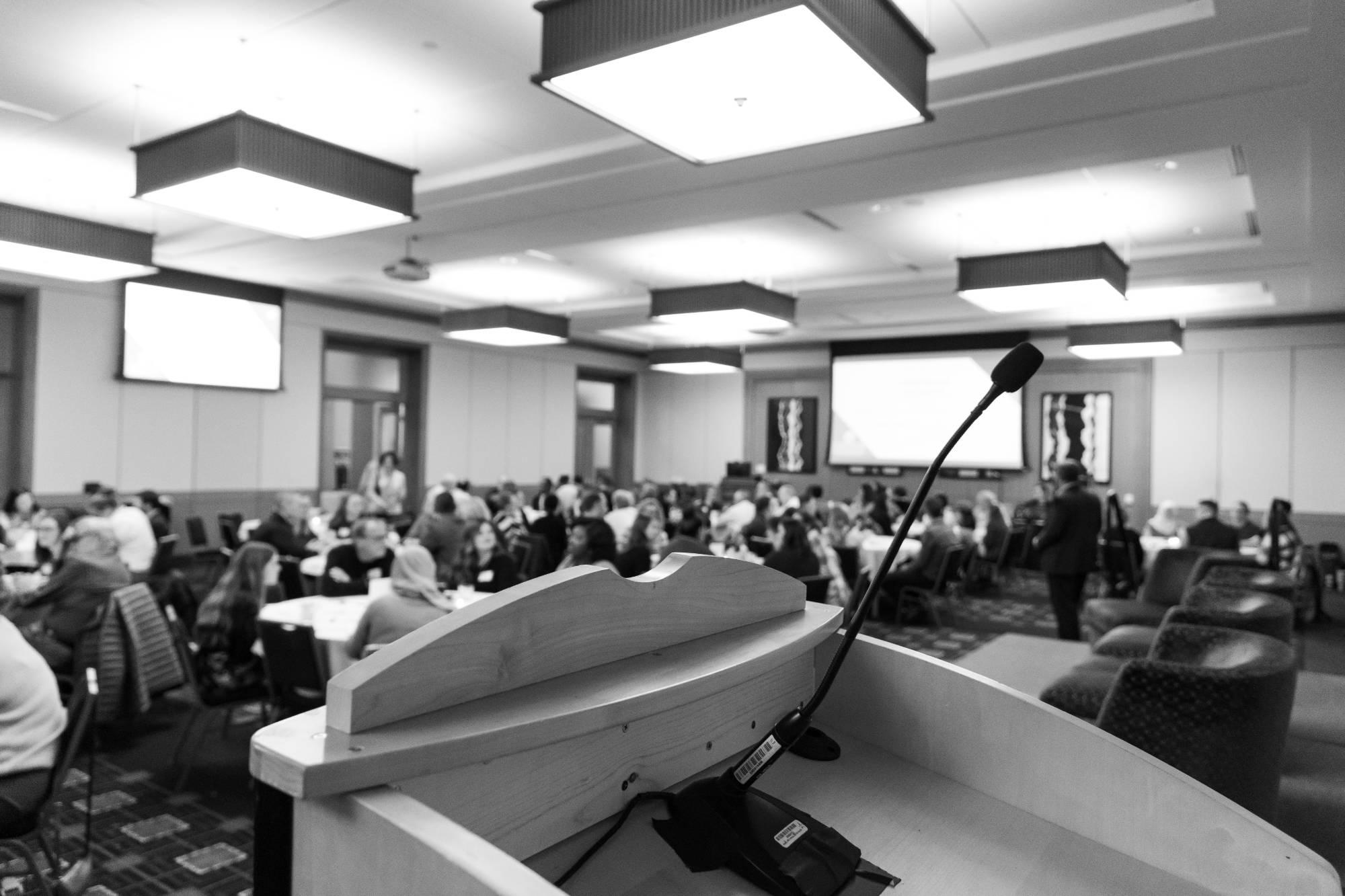 black and white photo of last years symposium, zoomed in on podium and mic